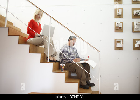 Couple assis sur les marches Banque D'Images