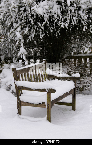 Siège de jardin en bois recouvert de neige un jardin Anglais UK Banque D'Images