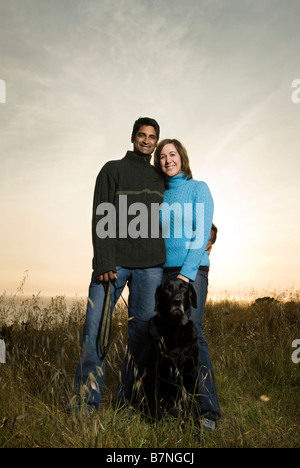 Couple avec chien au coucher du soleil en Californie sur hill Banque D'Images