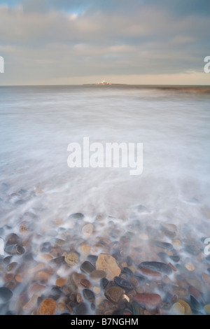 Marée montante sur les rochers et galets de lavage sur la plage à Hauxley près du village de flâner sur la côte de Northumbrie Banque D'Images