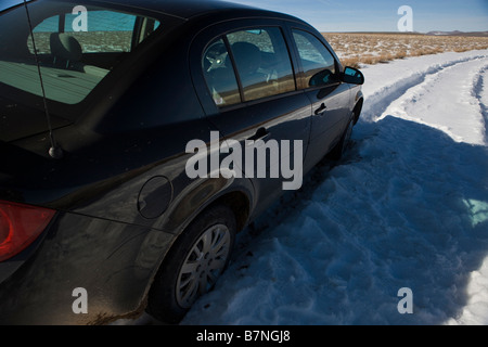 Une location de voiture Chevrolet noir est prisonnier sur une route enneigée à côté de l'armoise près de Summit Lake Nevada États-Unis d'Amérique Banque D'Images