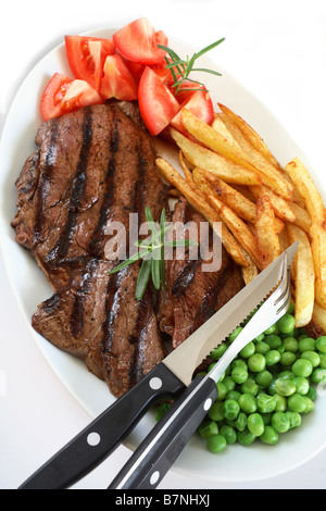 Un grill steak traditionnel avec pavé de rumsteak french fried chips de pomme de terre et les pois tomate garnie avec une branche de romarin Banque D'Images