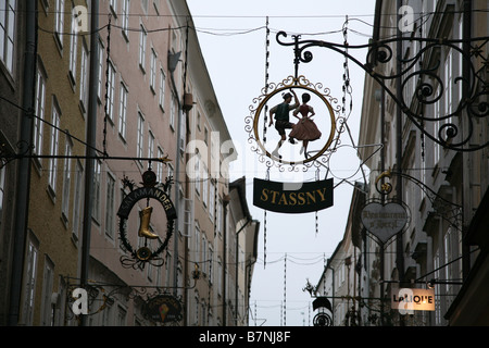 Enseignes en fer suspendu traditionnel sur les boutiques dans la rue Getreidegasse dans le centre historique de Salzbourg, en Autriche. Banque D'Images