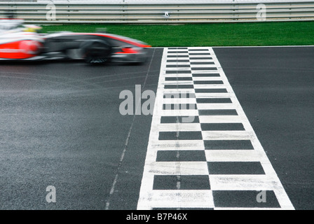 Lewis Hamilton (GB) dans la voiture de Formule 1 McLaren Mercedes franchit la ligne d'arrivée de racetrack Banque D'Images