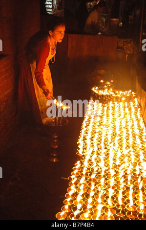 Femme allumant des bougies à Boudhanath Banque D'Images