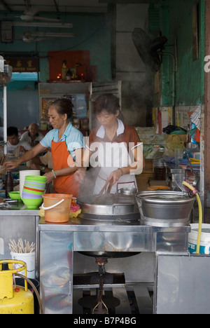 Deux femmes la préparation des aliments dans un restaurant ouvert à Georgetown, Penang, Malaisie Banque D'Images