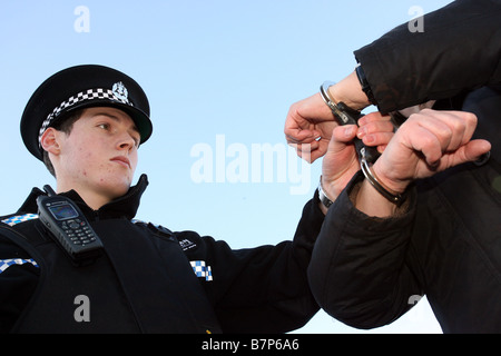 Agent de police de Grampian Aberdeen, Écosse, Royaume-Uni, les trains de placer un suspect en menottes Banque D'Images