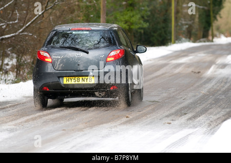 Mazda 2 driving on a snowy road 2009 Banque D'Images