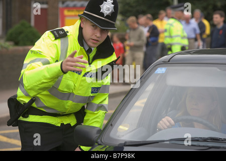 Constable spécial parle à un pilote si le trafic devoir en tant que partisans arrivent pour le match au stade de Watford Banque D'Images