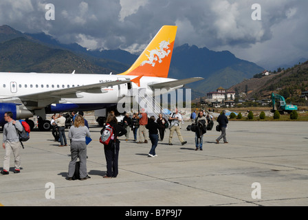 Les touristes descendent d'une vol Druk Air sur la piste de l'aéroport de Paro, Banque D'Images