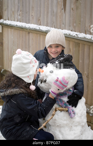 Enfants Garçon Fille Jardin d'hiver Bonhomme de Neige Foulard Banque D'Images