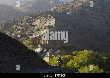 Un homme à cheval s'approche du village berbère. Banque D'Images