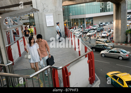 Les piétons à l'aide de la passerelle au-dessus de fort trafic Pathumwan, dans le centre de Bangkok, Thaïlande Banque D'Images