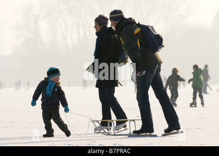 Homme Femme famille Père Mère un enfant enfant Luge Patinage sur glace tirant la surface gelée du lac Kralingse Rotterdam Pays-Bas Banque D'Images