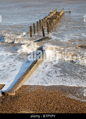 Les vagues déferlent contre l'épi en bois de défenses côtières Lowestoft Suffolk Angleterre Banque D'Images