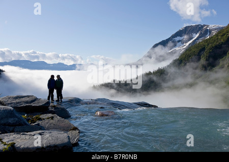 Deux personnes donnent sur le bord de la tombe de saumons rouges originaires de la Juneau Icefield, Taku River Valley ci-dessous dans le sud-est de l'Alaska Banque D'Images