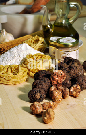 Noir et blanc frais truffes avec pots de beurre de truffe et préservé les truffes, pâtes aux truffes, de farine et d'huile d'olive Banque D'Images