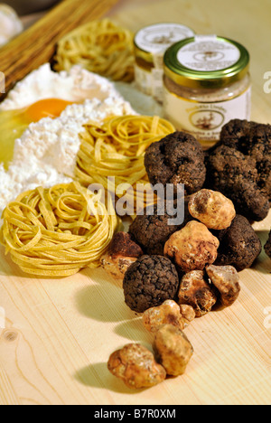 Noir et blanc frais truffes avec pots de beurre de truffe et préservé les truffes, pâtes aux truffes, de la farine et oeufs crus. Banque D'Images