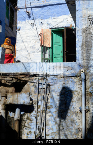 Brahmane traditionnel peint bleu chambre dans les petites rues de la vieille ville de Jodhpur avec femme indienne en costume local Banque D'Images