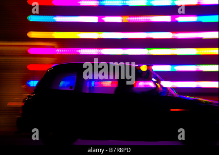 Un taxi conduit par le paysage urbain de Londres la nuit Banque D'Images