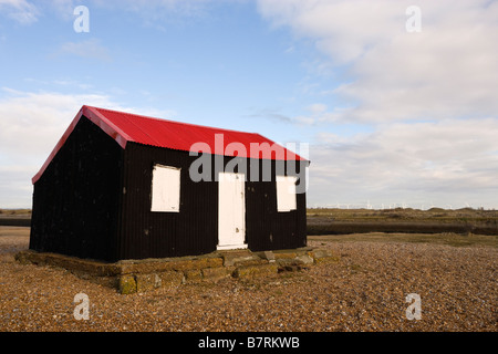 Une cabane au toit rouge sur les rives de la rivière de galets Rother, Rye à Sussex UK Banque D'Images