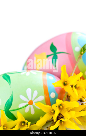 Les œufs de Pâques avec l'arrangement de fleurs de printemps isolé sur fond blanc Banque D'Images