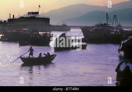 Silhouette d'un homme dans un petit bateau à rames, Aberdeen Harbour, Hong Kong, Chine Banque D'Images