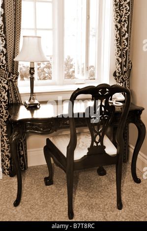 Chaise ancienne et d'un bureau près de la fenêtre dans la salle de séjour Banque D'Images