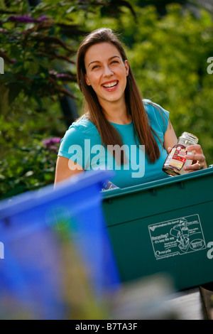 Jeune femme le tri le recyclage des bouteilles en verre et en plastique Banque D'Images