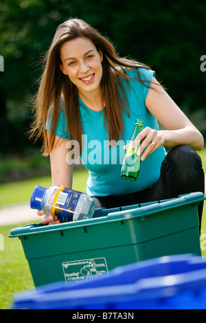 Jeune femme le tri le recyclage des bouteilles en verre et en plastique Banque D'Images