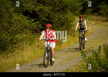 Mère et fille VTT à travers la forêt de Beddgelert Banque D'Images