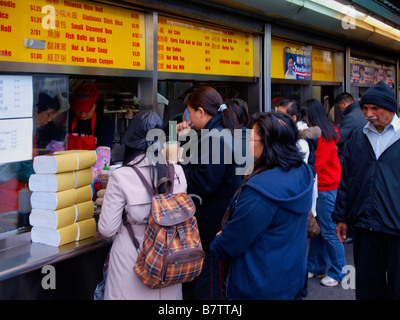 Commanditaires les commande d'un restaurant chinois à rue à New York City's quartier de rinçage. Banque D'Images