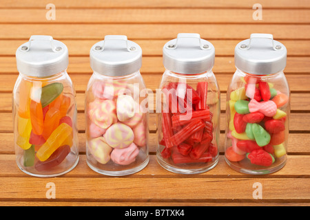 Assortiment de bocaux en verre avec des guimauves bonbons et réglisse rouge sur fond de bois profondeur de champ Banque D'Images