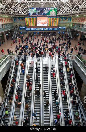 Des foules de voyageurs sur escaliers mécaniques de la gare ouest de Beijing au Nouvel An Chinois Janvier 2009 Chine Banque D'Images