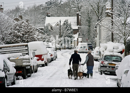 Rue de banlieue en charge de neige Banque D'Images