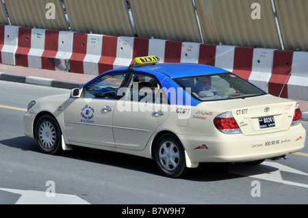 Vue latérale et arrière d'en haut, vue sur le bleu & Le taxi White Dubai taxi transport le long de la route rapide moderne Double chaussée Émirats arabes Unis Émirats Arabes Unis Banque D'Images