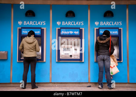 Les clients utilisant la banque Barclays trou dans le mur, High Street, Hounslow, Middlesex, Royaume-Uni. Banque D'Images