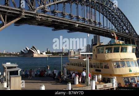 Milsons Point arrêt de ferry avec un ferry à l'avant-plan et Sydney Harbour Bridge et l'Opéra de Sydney dans l'arrière-plan Banque D'Images