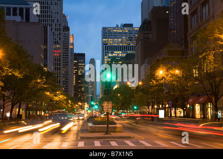 L'ILLINOIS Chicago Traffic signal en médiane de Michigan Avenue au crépuscule flou de voitures qui passent à gauche sur panneau de flèche Banque D'Images