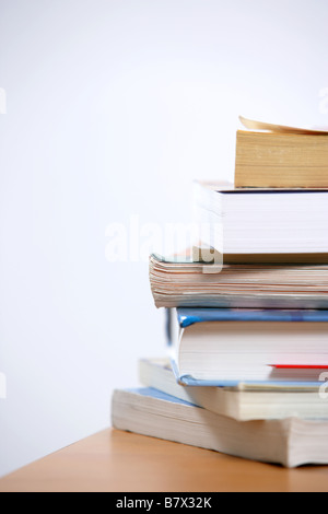 Une pile de livres assis sur le coin d'un bureau Banque D'Images