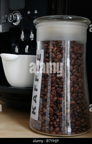 Grains de café torréfiés dans une bouteille en face de la banque une tasse dans un percolateur à café ; Banque D'Images