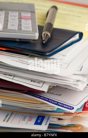 Stylo, calculatrice et vérifier livre assis sur un tas de projets de loi Banque D'Images