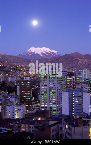 Pleine lune se levant au-dessus du Mont Illimani et des immeubles de grande hauteur dans le centre de la Paz, Bolivie Banque D'Images