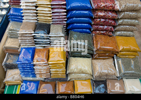 Pile d'épices enveloppés dans des sacs de nylon pour la vente à une boutique d'épices à Khan el Khalili au Caire Egypte Banque D'Images