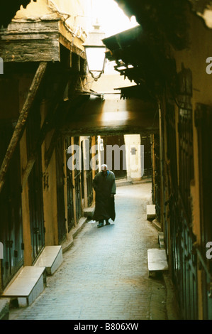 Un homme âgé portant une jellabah promenades le long d'une ruelle dans la médina : - tôt le matin, Fès el-Bali, Fes, Maroc, Afrique du Nord Banque D'Images