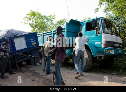 Deux camions ont coincé dans une tranchée boueuse dans la route et un troisième camion ont aimé passé la poussant vers le bas des arbres de la jungle au Nigeria Banque D'Images