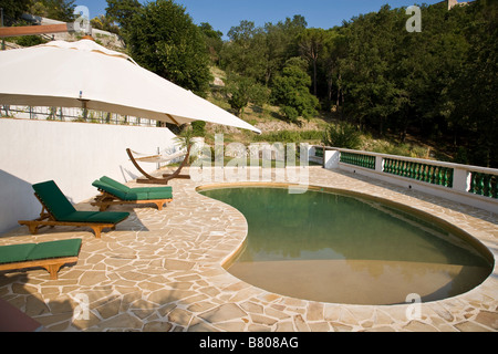 Près d'une piscine en forme de haricot en vacances Banque D'Images