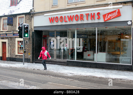 Une femme traverse la route en face de la magasin Woolworths local fermé à Frome. Banque D'Images