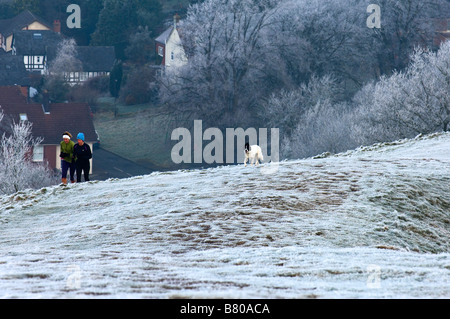 Deux jeunes femmes avec leurs chiens sont vus courir dans les collines de Malvern Worcestershire England Royaume-Uni Europe Banque D'Images