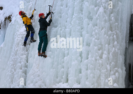 Paire de grimpeurs de glace s'arrêtant un reste sur un mur de glace à Tiffany Falls Ontario Canada Banque D'Images